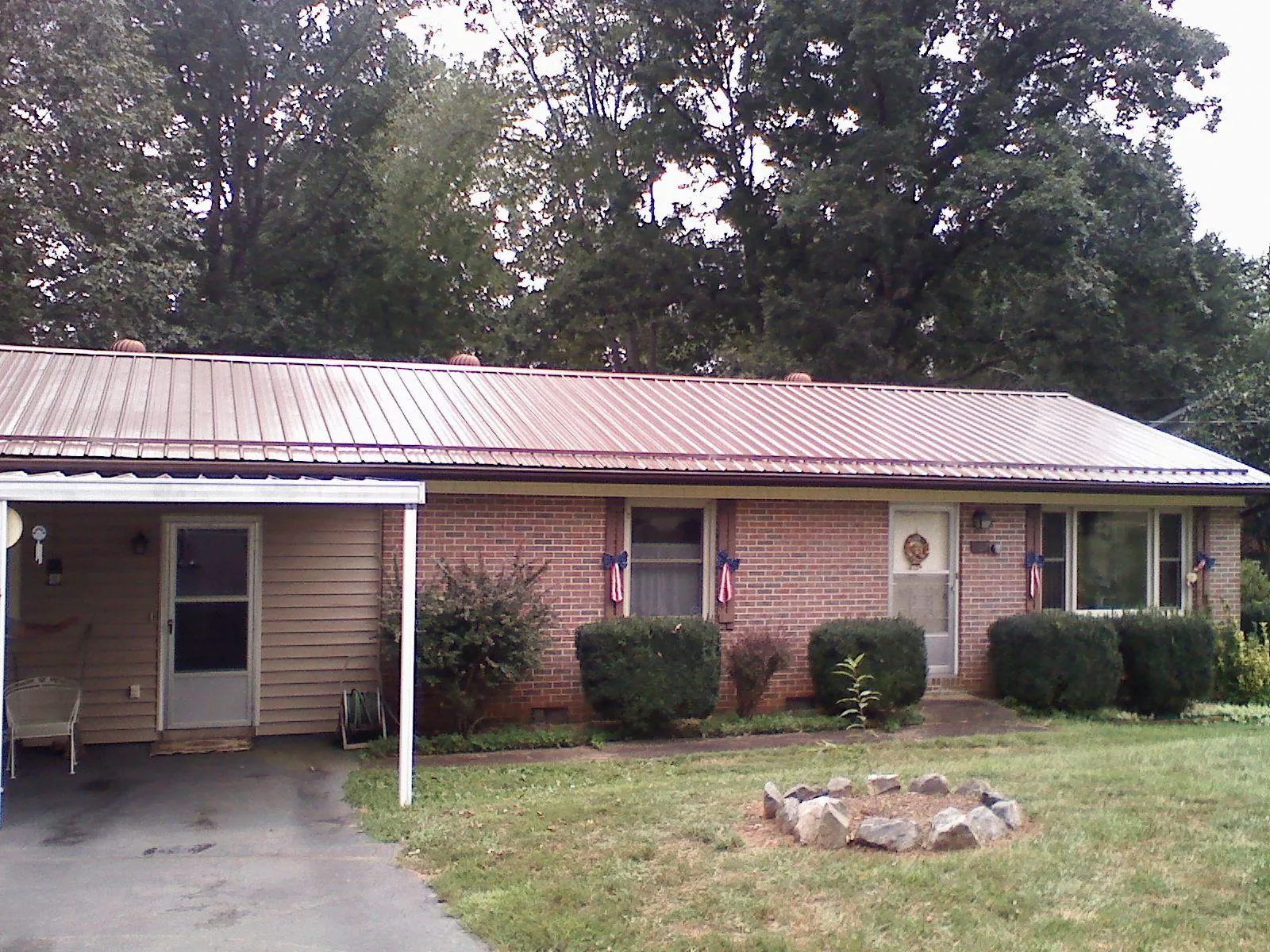 Bronze metal roof and carport on a brick ranch home — Roof Repair work by our crew in Braintree